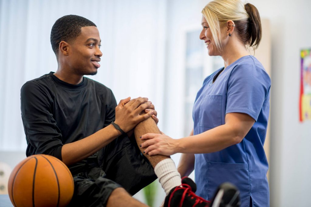 Doctor checking an athlete's injured knee