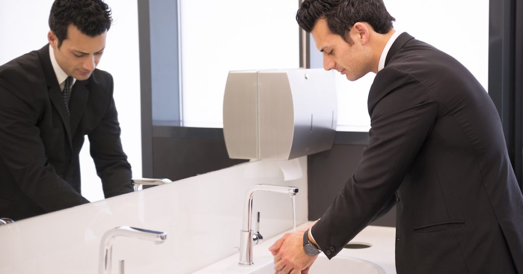 businessman washing his hands at restroom