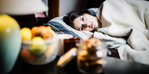 sick woman laying in bed