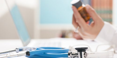 doctor working on a laptop testing medicine